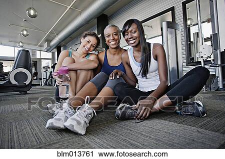 Smiling woman sitting on health club floor together View Large Photo Image Stock Image - Smiling woman sitting on health club floor together. Fotosearch
