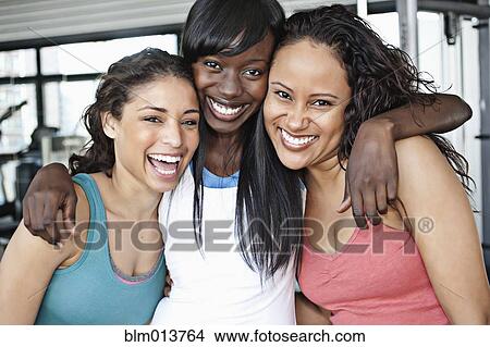 Smiling women hugging in health club View Large Photo Image Picture - Smiling women hugging in health club. Fotosearch