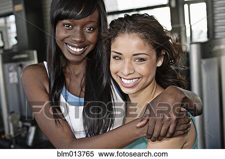 Smiling women hugging in health club View Large Photo Image Stock Photography - Smiling women hugging in health club. Fotosearch