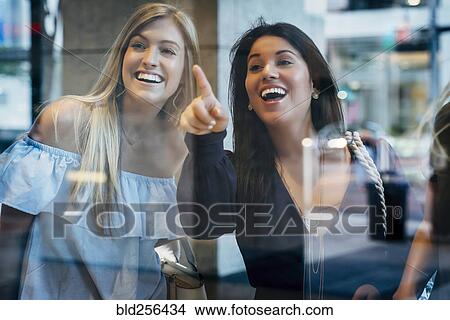 Smiling women window shopping View Large Photo Image Picture - Smiling women window shopping. Fotosearch