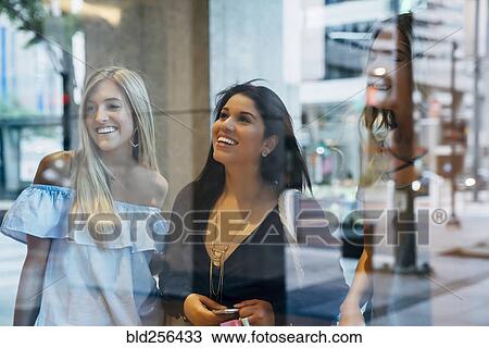 Smiling women window shopping View Large Photo Image Stock Image - Smiling women window shopping. Fotosearch