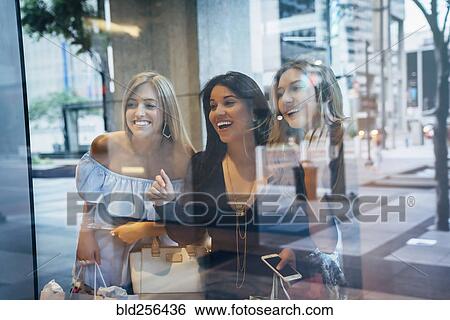 Stock Photograph - Smiling women window shopping. Fotosearch
