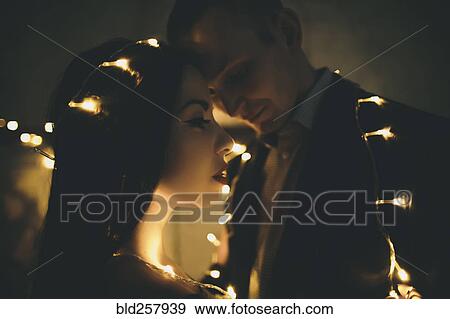 Stock Photo - String lights on Caucasian couple. Fotosearch