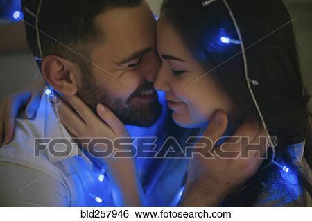 String lights on embracing Caucasian couple View Large Photo Image Stock Photograph - String lights on embracing Caucasian couple. Fotosearch