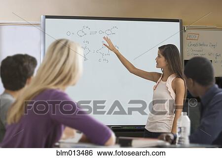 Stock Photograph - Student explaining formula in classroom. Fotosearch