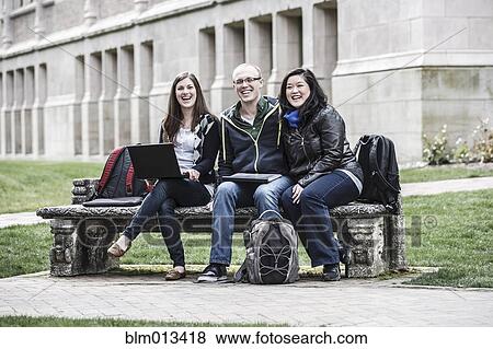 Students sitting on bench together View Large Photo Image Stock Photo - Students sitting on bench together. Fotosearch