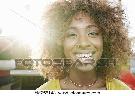 Sun beams on face of smiling black woman View Large Photo Image Stock Photo - Sun beams on face of smiling black woman. Fotosearch