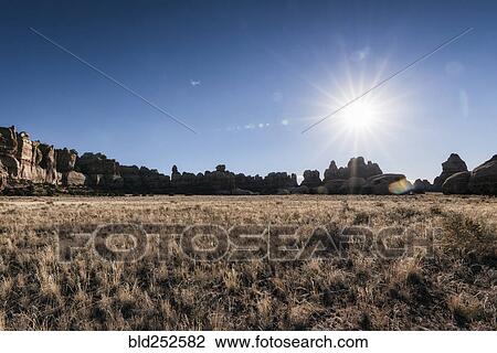 Stock Image - "Sun in blue sky over desert, Moab, Utah, United States". Fotosearch