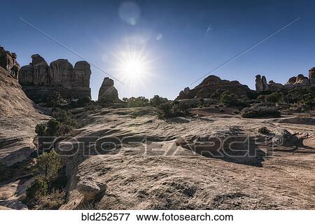 Stock Photo - "Sun in blue sky over desert, Moab, Utah, United States". Fotosearch