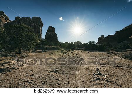 Stock Photo - "Sun in blue sky over desert, Moab, Utah, United States". Fotosearch