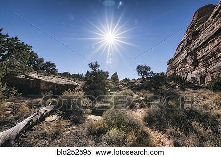Stock Photography - "Sun in blue sky over desert, Moab, Utah, United States". Fotosearch