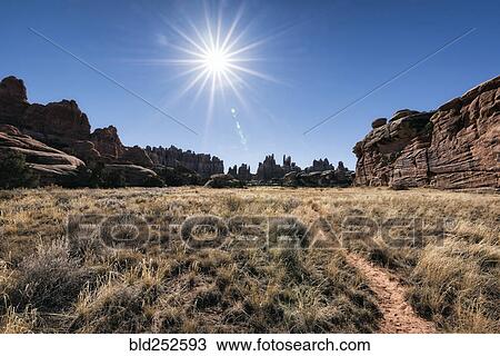 "Sun in blue sky over desert path, Moab, Utah, United States" View Large Photo Image Stock Image - "Sun in blue sky over desert path, Moab, Utah, United States". Fotosearch