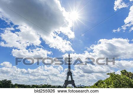 Stock Photograph - "Sunbeams over distant Eiffel Tower, Paris, Ile de France, France". Fotosearch