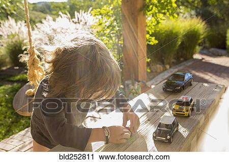 Sunshine on a Caucasian boy playing with toy cars View Large Photo Image Stock Image - Sunshine on a Caucasian boy playing with toy cars. Fotosearch