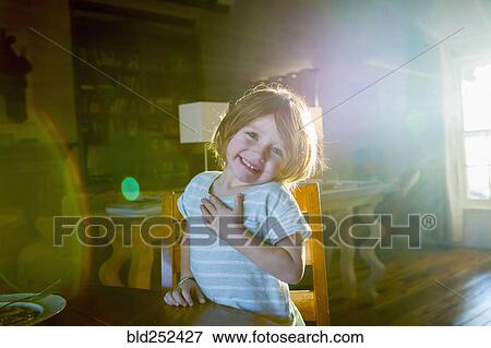 Sunshine on Caucasian boy sitting at table View Large Photo Image Stock Photo - Sunshine on Caucasian boy sitting at table. Fotosearch