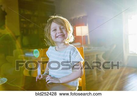 Sunshine on Caucasian boy sitting at table View Large Photo Image Stock Photo - Sunshine on Caucasian boy sitting at table. Fotosearch