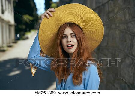 Surprised Caucasian woman holding hat near stone wall View Large Photo Image Stock Photo - Surprised Caucasian woman holding hat near stone wall. Fotosearch