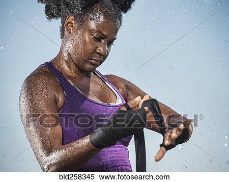 Stock Photography - Sweating Black boxer wrapping hands. Fotosearch