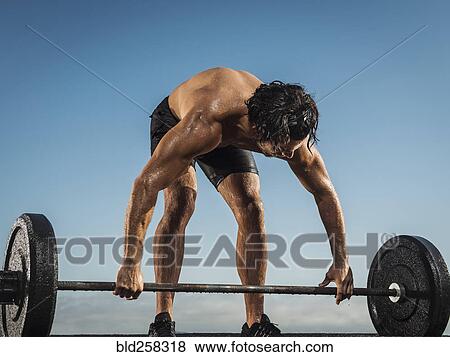 Sweating Hispanic man lifting barbell View Large Photo Image Stock Photo - Sweating Hispanic man lifting barbell. Fotosearch