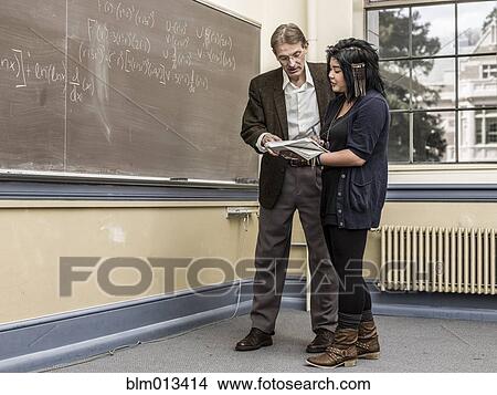 Picture - Teacher helping student in classroom. Fotosearch