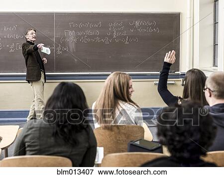 Stock Photo - Teacher talking to students in classroom. Fotosearch