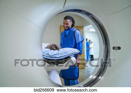 Stock Photo - Technician talking to patient near scanner. Fotosearch