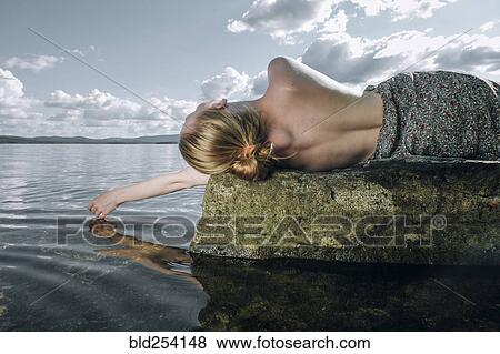 Topless Caucasian teenage girl laying on rock in ocean View Large Photo Image Stock Photo - Topless Caucasian teenage girl laying on rock in ocean. Fotosearch