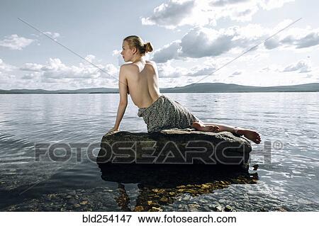 Topless Caucasian teenage girl sitting on rock in ocean View Large Photo Image Stock Photo - Topless Caucasian teenage girl sitting on rock in ocean. Fotosearch