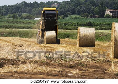 Stock Photo - Tractor baling hay in field. Fotosearch