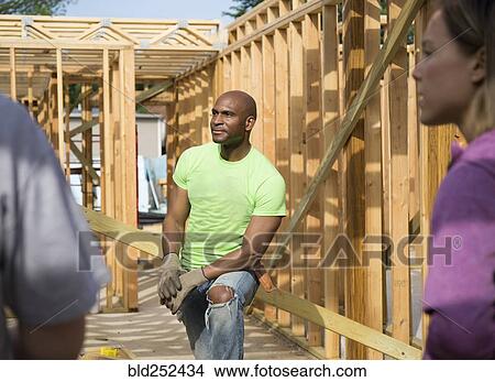 Volunteers listening while building house View Large Photo Image Picture - Volunteers listening while building house. Fotosearch