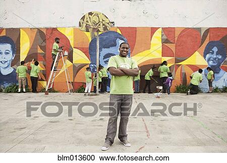Stock Image - Volunteers painting wall. Fotosearch