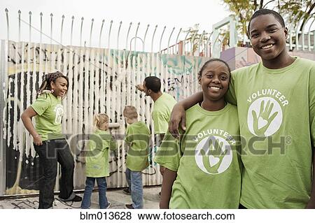 Stock Photo - Volunteers painting wall. Fotosearch