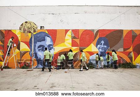 Stock Photo - Volunteers painting wall together. Fotosearch