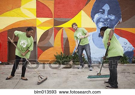 Stock Image - Volunteers sweeping ground. Fotosearch