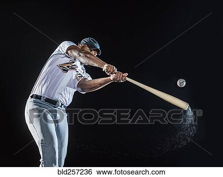Stock Photograph - Water splashing from swinging bat of black baseball player. Fotosearch