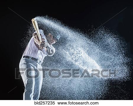 Stock Photography - Water splashing from swinging bat of black baseball player. Fotosearch