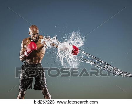 Stock Image - Water splashing on black boxer punching. Fotosearch
