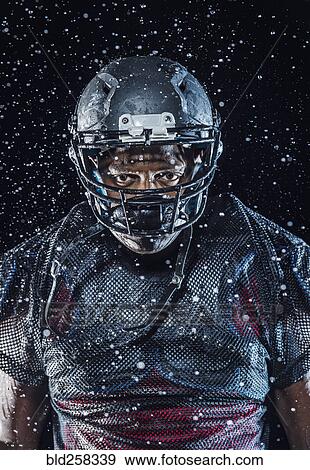 Stock Photo - Water splashing on Black football player wearing helmet. Fotosearch