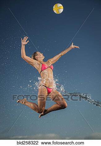 Water splashing on Caucasian woman jumping to volleyball View Large Photo Image Stock Image - Water splashing on Caucasian woman jumping to volleyball. Fotosearch