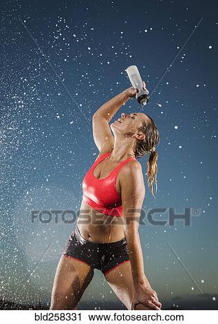 Water splashing on Caucasian woman cooling off with water bottle View Large Photo Image Stock Image - Water splashing on Caucasian woman cooling off with water bottle. Fotosearch