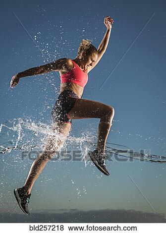 Water splashing on Caucasian woman running in sky View Large Photo Image Stock Photo - Water splashing on Caucasian woman running in sky. Fotosearch