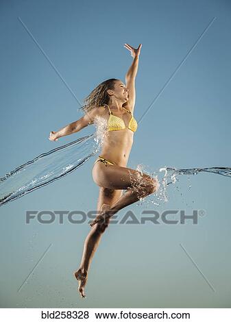 Water splashing on Caucasian woman jumping in bikini View Large Photo Image Stock Photo - Water splashing on Caucasian woman jumping in bikini. Fotosearch