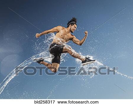 Water splashing on Hispanic man running and jumping View Large Photo Image Stock Photo - Water splashing on Hispanic man running and jumping. Fotosearch