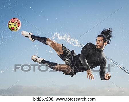 Water spraying on Hispanic man kicking soccer ball View Large Photo Image Stock Photo - Water spraying on Hispanic man kicking soccer ball. Fotosearch