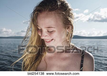 Stock Photo - Wind blowing hair of Caucasian teenage girl in ocean. Fotosearch