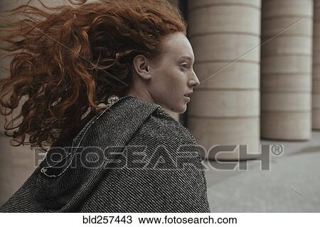 Stock Image - Wind blowing hair of Caucasian woman near pillars. Fotosearch