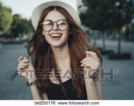 Stock Photograph - Wind blowing hair of laughing Caucasian woman. Fotosearch