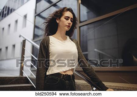 Wind blowing hair of pensive Caucasian woman on staircase View Large Photo Image Picture - Wind blowing hair of pensive Caucasian woman on staircase. Fotosearch