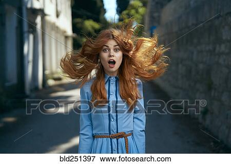 Stock Photo - Wind blowing hair of surprised Caucasian woman. Fotosearch