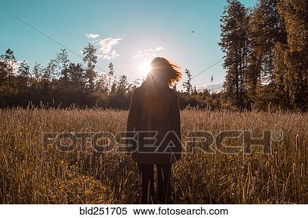 Wind blowing hair of woman standing in field View Large Photo Image Stock Photography - Wind blowing hair of woman standing in field. Fotosearch